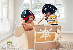 Kids playing in a box as a pirate boat